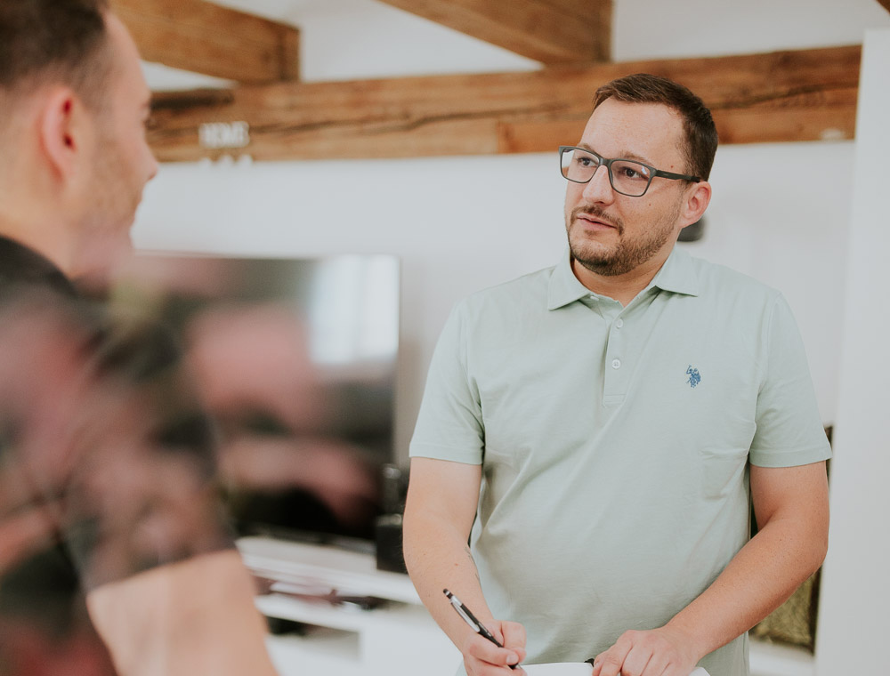 Immobilienberater Fabian macht sich Notizen beim Marktcheck im Kundengespräch